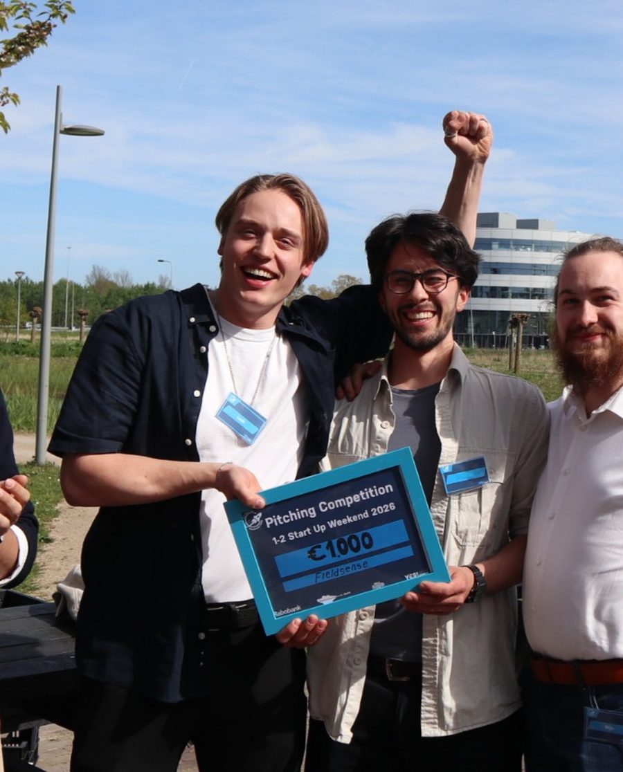 Three of the UNAMIQ founders holding a pitching-competition prize board