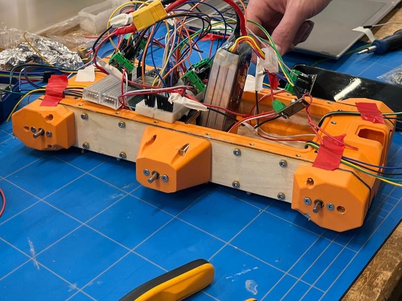 The Outdoor-UGV chassis open on a workbench, showing its internal wiring and electronics